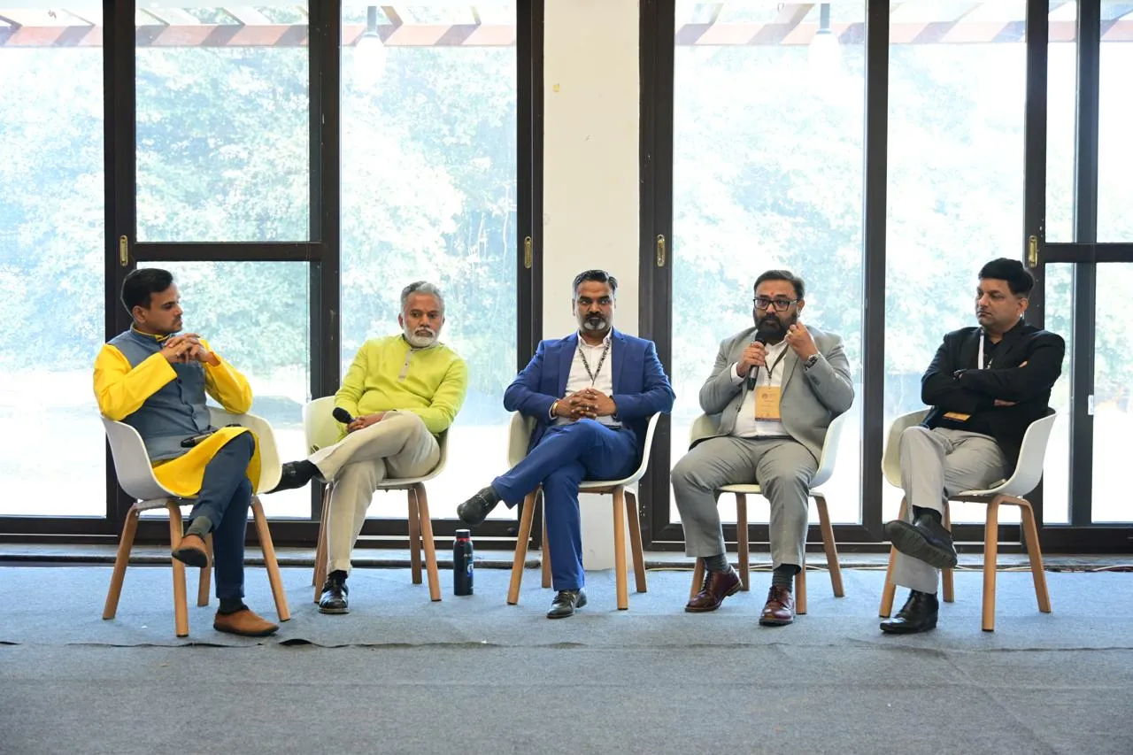 Kirtiraj Gohil, fourth from left, answering into a microphone on a five-person industry panel